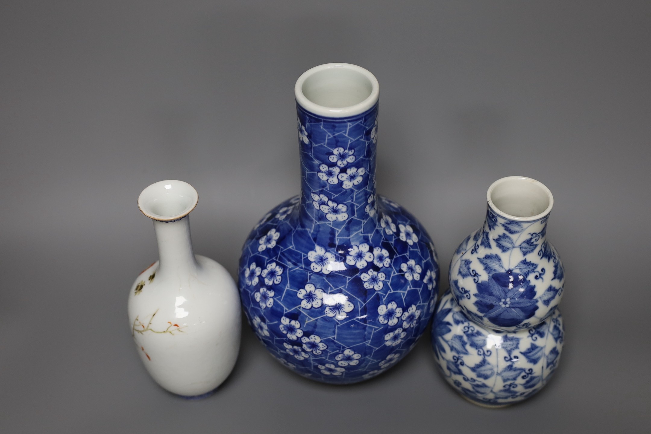 A Chinese blue and white bottle vase, a similar double gourd vase and a famille rose bottle vase a.f., tallest 26cm